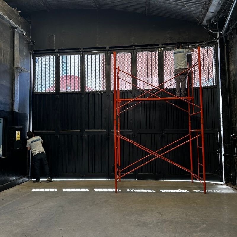 Mantenimiento preventivo en portón curvo-corredizo. Mantenimiento preventivo, ajuste y nivelación de un portón curvo-corredizo de 7 paneles. El trabajo se realizó en altura con andamiaje para garantizar una calibración precisa. Trabajo realizado por HERREELEC.